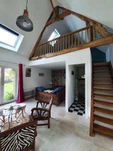 ein Wohnzimmer mit einer Treppe und ein Schlafzimmer in der Unterkunft Atelier aux Dimes in Le Manoir