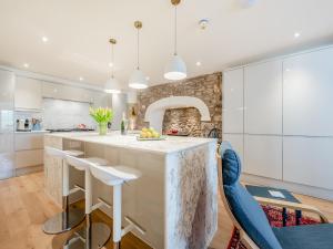 a kitchen with a large island with bar stools at The Anchorage in Pembroke