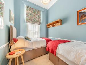 a bedroom with blue walls and a bed and a table at The Anchorage in Pembroke
