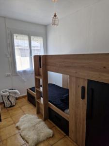 a bedroom with a bunk bed and a window at La Maison de Léonie sur Vias in Vias