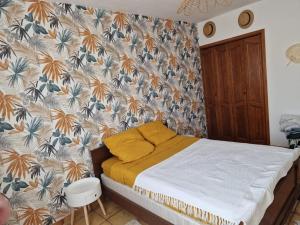 - une chambre avec un lit et un papier peint floral dans l'établissement La Maison de Léonie sur Vias, à Vias