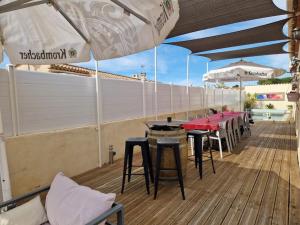 a patio with tables and umbrellas on a deck at La Maison de Léonie sur Vias in Vias