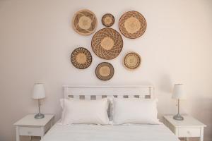 sypialnia z łóżkiem z czterema kapeluszami na ścianie w obiekcie Camps Bay Guest Suite with private pool w Kapsztadzie