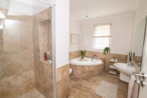 a bathroom with a tub and a sink at Camps Bay Guest Suite with private pool in Cape Town