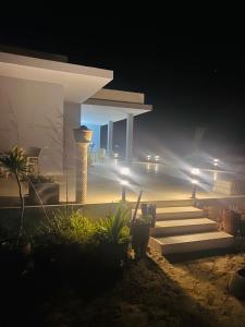 a house with a set of stairs at night at Beach house wing in kerkennah island. Fully equipped place for 4 guests and peaceful relaxing stay. Calm sea and beautiful sun rise that can be enjoyed straight on the beach or from the house terrace. in Ouled Yaneg