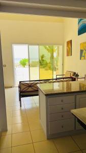 a kitchen with a view of a living room at Beach house wing in kerkennah island. Fully equipped place for 4 guests and peaceful relaxing stay. Calm sea and beautiful sun rise that can be enjoyed straight on the beach or from the house terrace. in Ouled Yaneg