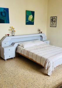 um quarto com uma cama branca e uma cómoda branca em Beach house wing in kerkennah island. Fully equipped place for 4 guests and peaceful relaxing stay. Calm sea and beautiful sun rise that can be enjoyed straight on the beach or from the house terrace. em Ouled Yaneg