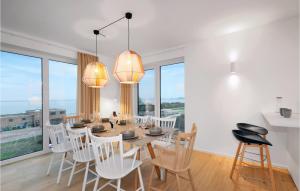 a dining room with a table and chairs and windows at Penthouse Deluxe in Lembruch