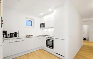a white kitchen with white cabinets and a window at Penthouse Deluxe in Lembruch