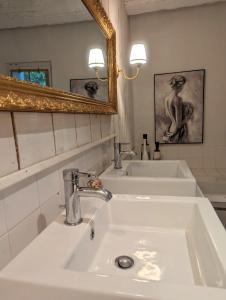 La salle de bains est pourvue d'un lavabo blanc et d'un miroir. dans l'établissement Maison Pimoli : Chambre Hortense, à Soustons