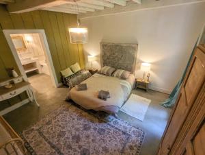 a bedroom with a bed and a couch in it at Maison Pimoli : Chambre Hortense in Soustons