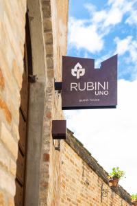 un panneau sur le côté d'un bâtiment dans l'établissement Rubini Uno Guest House, à Gradara