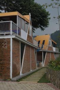 a brick building with a balcony on top of it at De Pointé Resort & Resto in Campaka