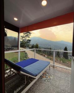 a room with a bed on a balcony with a view at De Pointé Resort & Resto in Campaka