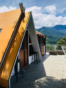 a small house with a roof with a view of mountains at De Pointé Resort & Resto in Campaka