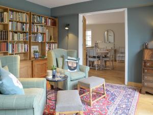 een woonkamer met een bank, stoelen en een tafel bij Pear Tree Cottage in Southburgh