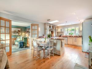 een keuken en een woonkamer met een tafel en stoelen bij Pear Tree Cottage in Southburgh