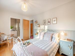 a bedroom with a bed and a dining room at Pear Tree Cottage in Southburgh