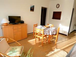 ein Esszimmer mit einem Tisch, Stühlen und einem TV in der Unterkunft Appartement Saint-Lary-Soulan, 2 pièces, 4 personnes - FR-1-457-218 in Saint-Lary-Soulan
