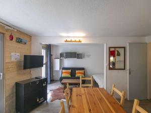 a living room with a table and a couch at Appartement Cauterets, 2 pièces, 5 personnes - FR-1-401-229 in Cauterets