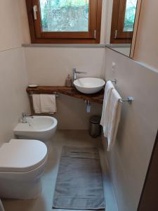 ein Badezimmer mit einem Waschbecken, einem WC und einem Spiegel in der Unterkunft 44 Ricci in Anghiari