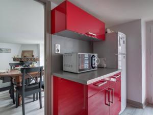 uma cozinha com armários vermelhos e um micro-ondas em Appartement Cauterets, 3 pièces, 6 personnes - FR-1-401-49 em Cauterets