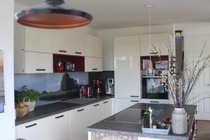 uma cozinha com armários brancos e bancadas pretas em Ferienhaus Zur Oie em Bresewitz