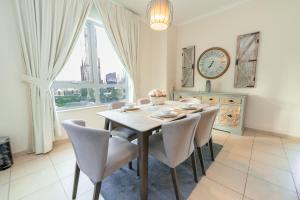 uma sala de jantar com mesa e cadeiras e um relógio em FAM Living - The Residences Tower - Burj Khalifa & Fountain Views em Dubai