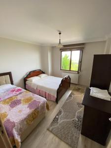 a bedroom with two beds and a window at Menekşe Apart 2 in Trabzon