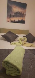 - un lit avec une couverture verte dans l'établissement Apartments Ars Vivendi, à Trogir