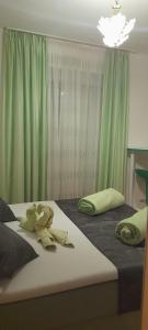 1 dormitorio con 2 camas y cortinas verdes en Apartments Ars Vivendi, en Trogir