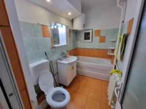 a bathroom with a toilet and a sink and a tub at Vali Apart in Mangalia