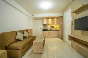 een woonkamer met een bruine bank en een keuken bij Premium 2BR @ Bassura City East Jakarta in Jakarta