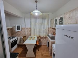 a small kitchen with a table and a refrigerator at Vali Apart in Mangalia