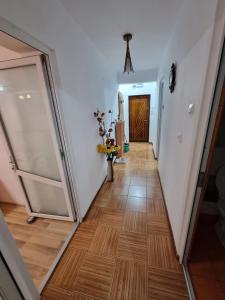 a hallway with a wooden floor and a door at Vali Apart in Mangalia