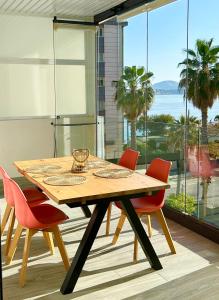 - une table à manger avec des chaises et une vue sur l'océan dans l'établissement Calpe Beach II - sea & pool view apartment, à Calp