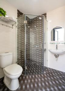 a bathroom with a shower and a toilet and a sink at Jan Hostel Central Point in Ho Chi Minh City