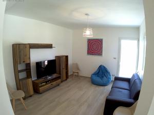 ein Wohnzimmer mit einem Sofa und einem TV in der Unterkunft Villa Alice in Molfetta