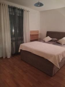 - une chambre avec un grand lit et une fenêtre dans l'établissement Apartments Ars Vivendi, à Trogir