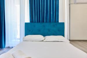 Una cama con cabecera azul en una habitación. en Studio Melody Nord 10, en Năvodari 33 fotos más