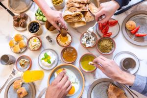 eine Gruppe von Menschen, die an einem Tisch essen in der Unterkunft Kassa Boutique Hotel in Bethlehem