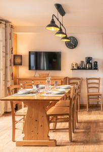 - une salle à manger avec une table et des chaises en bois dans l'établissement Résidence les Terrasses De La Bergerie (by Sabine et JeanKry), à Orcières