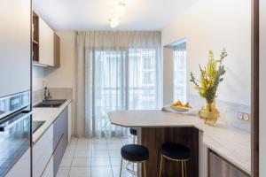 a kitchen with two bar stools and a counter top at Le Mont-Veyrier, parking et vue in Annecy