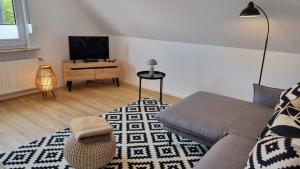 a living room with a couch and a tv at Haus Polarstern Ferienwohnung Kapella in Borkum