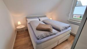 a bed with two pillows on it in a room at Haus Polarstern Ferienwohnung Kapella in Borkum