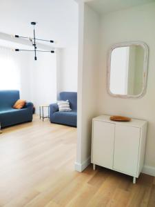 sala de estar con espejo y sofá azul en ESPECIAL HOME apartamento reformado 6 huéspedes en Avilés