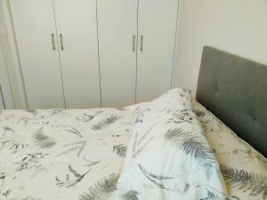 1 dormitorio con 1 cama con manta y armarios blancos en ESPECIAL HOME apartamento reformado 6 huéspedes en Avilés