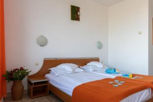 HOTEL DUNĂREA في مامايا: غرفة نوم مع سرير وبطانية برتقالية