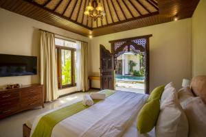 ein Schlafzimmer mit großem Bett und großem Fenster in der Unterkunft Villa Katara in Seminyak
