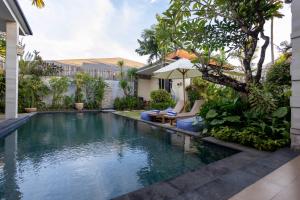 ein Swimmingpool im Hinterhof eines Hauses in der Unterkunft Villa Katara in Seminyak